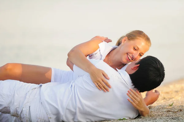 Ευτυχισμένη αγάπη ζευγάρι σε μια φωτεινή ηλιόλουστη ημέρα βρίσκονται πάνω στην παραλία, μπλε-eyed ξανθιά — Φωτογραφία Αρχείου