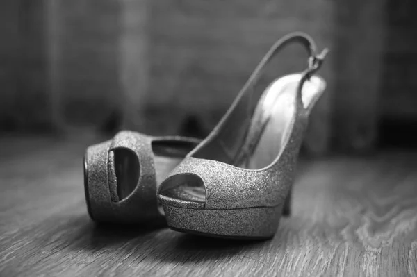 Scarpe femminili sono distesi sul pavimento su uno sfondo semi-scuro — Foto Stock