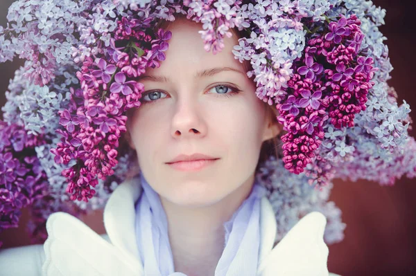 Foto de moda al aire libre de una hermosa joven mujer de ojos azules. Color primavera. hermosa chica rubia en flores lila. Perfume con olor a flores. Perfumes y belleza — Foto de Stock