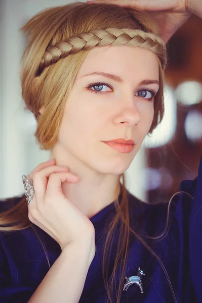 Jolie femme blonde aux cheveux tressés jouant, les mains sur la tête habillée d'une robe bleue, beau portrait dans la maison, image simple de la maison, soin des cheveux — Photo