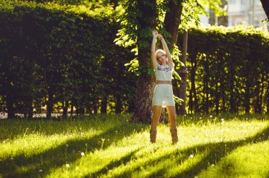 ihale kadın sarışın yürüyüşler karşı doğal bir etnik giyinmiş akşam güneşi fon çimenlerin üzerinde elbise, şık ve rahat. Doğanın aşk kavramı.