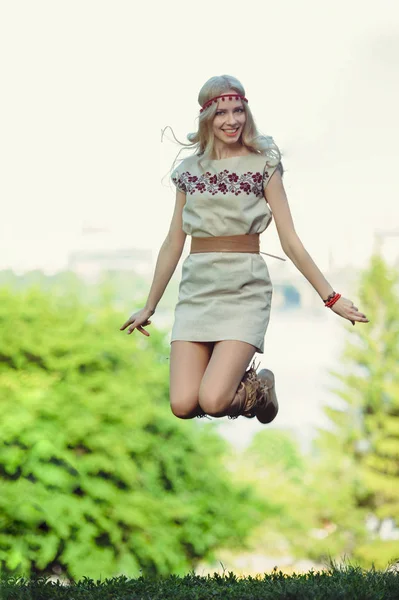 温柔的金发女郎跳跃着看着远处 穿着一件自然的连衣裙 时髦而舒适 自然的爱的概念 — 图库照片