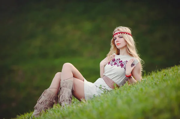 温柔的金发女郎坐在草地上 穿着天然的绣衣绷带在她的头上 在绿色的背景时尚和舒适 广告的概念 对自然的热爱 文本位置 — 图库照片