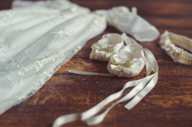 vaftiz bebek elbise ve ayakkabı. Şirin yeni doğan close-up. küçük Ayakkabı ve ahşap arka plan üzerinde elbise. Kavram çocukluk eğitimi ve moda.