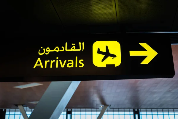 Airport arrival sign and transfer sign - flight arrival and transfer yellow sign at airport in English and Arabic