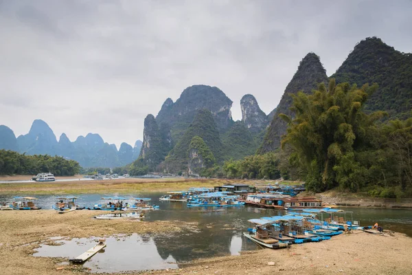 Yangshuo, China - circa February 2017: Bamboo rafts and boats in port on Li river in Yangshuo Guilin China. Boat and raft cruises are one of the most popular tourist attractions in China