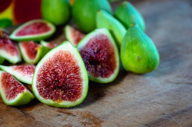 İncir. Taze incir ve dilimlenmiş incir meyveleri. Kesme tahtasındaki dokuyu gösteriyor.