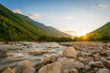 Gürcistan 'ın Svaneti bölgesindeki Mestia köyü yakınlarında gün batımında dağlar ve nehirle kaplı Svaneti manzarası..