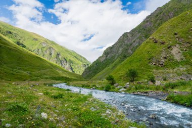 Gürcistan 'ın Kazbegi kentinde nehir manzaralı dağ manzarası - Kafkasya' da popüler macera yürüyüşü ve yürüyüş bölgesinin dramatik manzarası. 