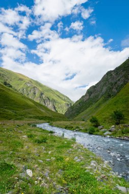Gürcistan 'ın Kazbegi kentinde nehir manzaralı dağ manzarası - Kafkasya' da popüler macera yürüyüşü ve yürüyüş bölgesinin dramatik manzarası. 