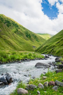 Gürcistan 'ın Kazbegi kentinde nehir manzaralı dağ manzarası - Kafkasya' da popüler macera yürüyüşü ve yürüyüş bölgesinin dramatik manzarası. 