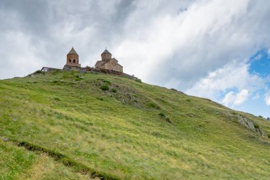 Gergeti Trinity Kilisesi ya da Tsminda Sameba, bulutlu dramatik bir yer. Gergeti Kilisesi Gürcistan 'ın Gergeti köyünün yakınında Kazbegi Dağı' nın altında duruyor.