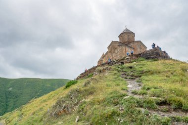 Gergeti Trinity Kilisesi ya da Tsminda Sameba, bulutlu dramatik bir yer. Gergeti Kilisesi Gürcistan 'ın Gergeti köyünün yakınında Kazbegi Dağı' nın altında duruyor.