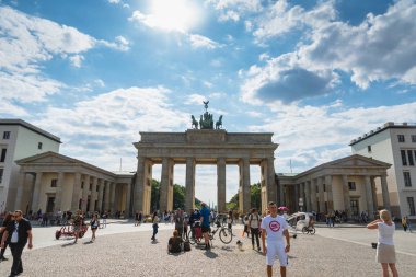 Berlin, Almanya - Temmuz 2019: Brandenburg kapısı ve Berlin 'de güneşli bir yaz gününde ziyaretçiler. Brandenburg kapısı şehrin ana simgelerinden biridir..