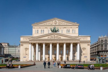 Moskova, Rusya - Nisan 2019: Güneşli bahar gününde Bolşoy Tiyatrosu ve Moskova, Rusya 'da tarihi bir tiyatro olan tiyatronun önündeki ziyaretçiler.