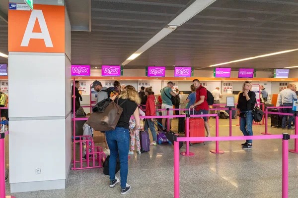 Varşova, Polonya - Temmuz 2019: Wizz Air kontrol gişesi ve Varşova Chopin Havaalanı 'nda bekleyen yolcular. Wizz Air, tüm Avrupa 'da hizmet veren düşük maliyetli Macar havayolu şirketidir..
