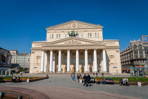 Moskova, Rusya - Nisan 2019: Güneşli bahar gününde Bolşoy Tiyatrosu ve Moskova, Rusya 'da tarihi bir tiyatro olan tiyatronun önündeki ziyaretçiler.