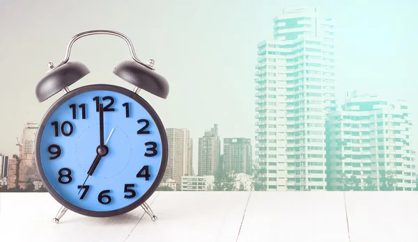 Μπλε ρολόι-ξυπνητήρι με σύγχρονη πόλη σε παστέλ τόνος — Φωτογραφία Αρχείου