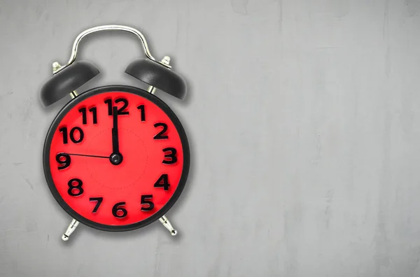 Red Alarm clock lunch time on gray cement background with copy space.