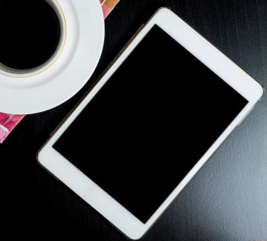 Kahve kupa siyah parlak masada boş boş tablet ekranıyla