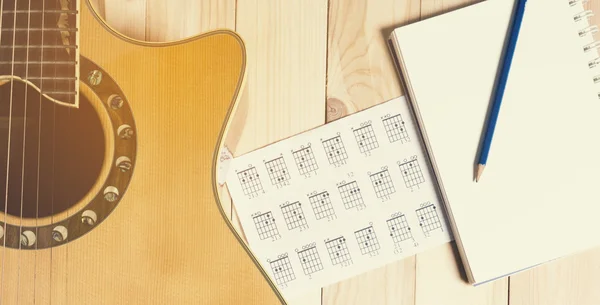 Guitarra con libreta en blanco para escribir canciones . — Foto de Stock