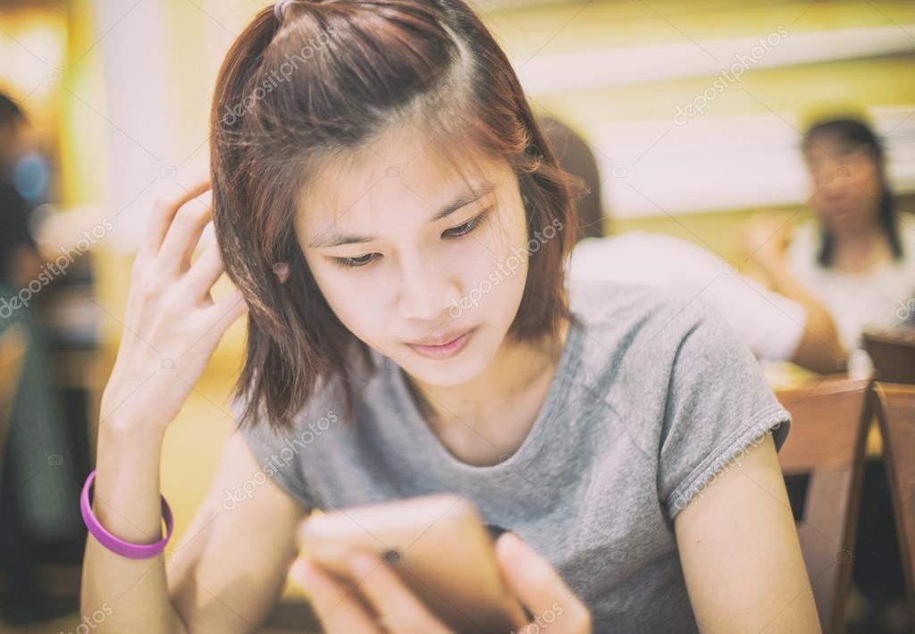 Cute Short Hair Asian Girl Using A Mobile Phone In Cafe Stock