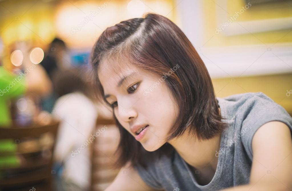 Cute Short Hair Asian Women Sitting In A Restaurant Stock