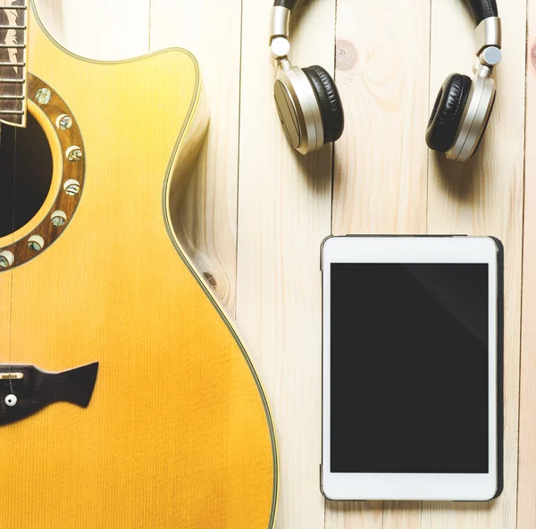 Guitarra acústica con auriculares y tableta para practicar música y escribir música . — Foto de Stock