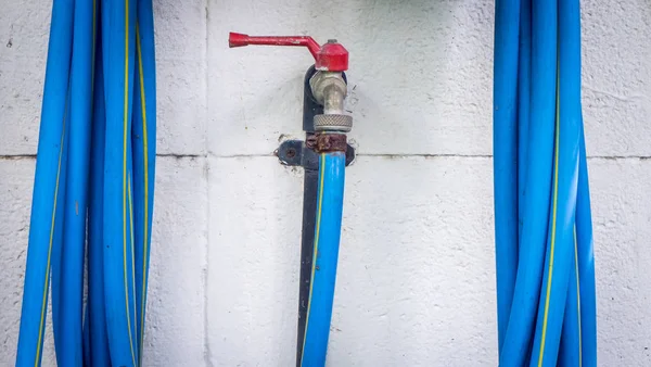 Rustieke muur waterkraan met blue host — Stockfoto
