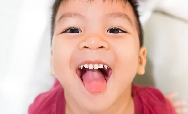Aziatische jongen met zijn tong uit zijn mond open. — Stockfoto