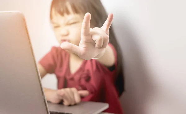 Chica asiática mostrando Amor o metal pesado signo de la mano mientras se utiliza el ordenador portátil navegar por Internet . —  Fotos de Stock