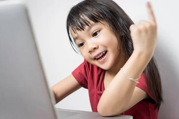 Chica asiática se ve muy interesante con el contenido en el ordenador. El contenido en Internet está haciendo muy feliz a la niña. Japonesa chica es conseguir inteligente y la idea de su ordenador portátil . —  Fotos de Stock