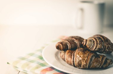 Kruvasan ve kahve kırmızı alarm saati ile kahvaltıda