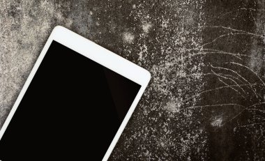 Bir kaba çimento duvar kopya alanı ile ekranda boş tablet.