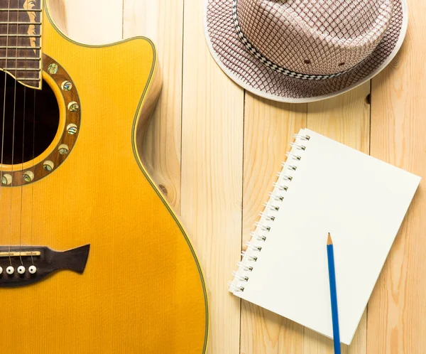 Gitar müzik ve ahşap arka plan üzerine yaz şapka müzik yazma.