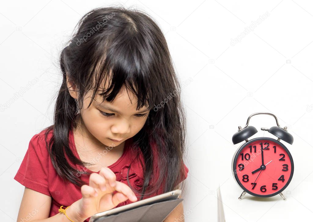 Asian girl is holding an alarm clock that count for lunch time.