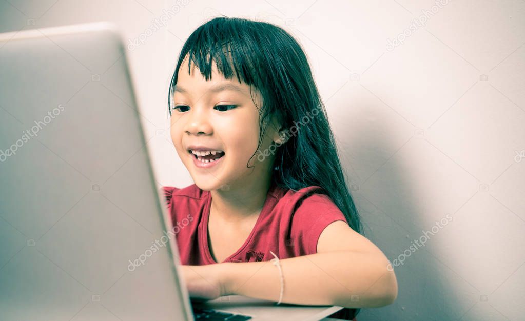 Asian kid is enjoy addiction of Computer and Internet.