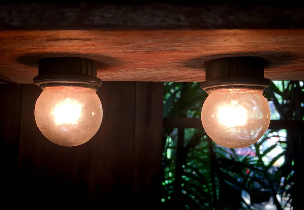 Zwei alte Glühbirnen an einer Holzdecke. — Stockfoto