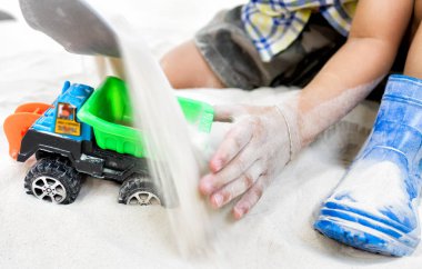 Bir kum Bahçesi oyuncak araba ile oynayan çocuk.