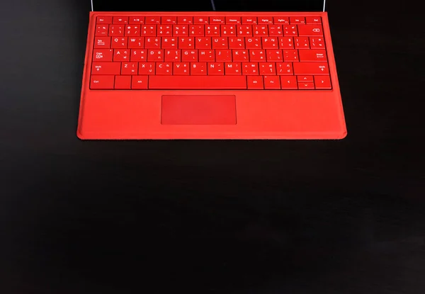 Rote tragbare Computertastatur auf schwarzem Tisch mit Kopierraum. — Stockfoto