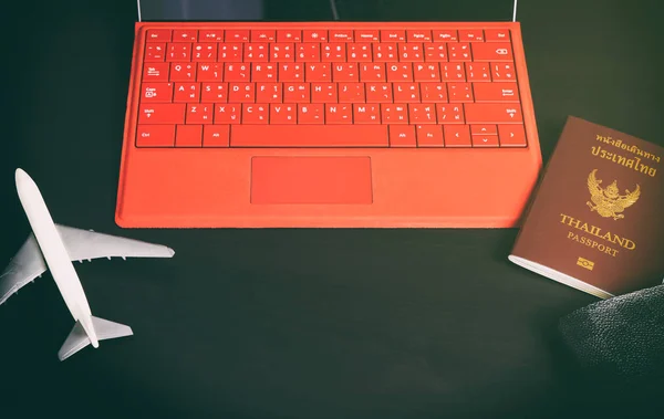 Concepto de viaje de negocios con pasaporte de teclado copia y avión en mesa oscura . — Foto de Stock