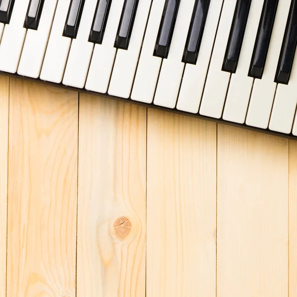 Tasti di tastiera musicale su tavolo quadrato in legno con spazio copia — Foto Stock