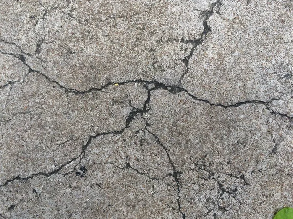 Popraskané rozbité grunge betonová silnice patře zeď šedá barva. — Stock fotografie