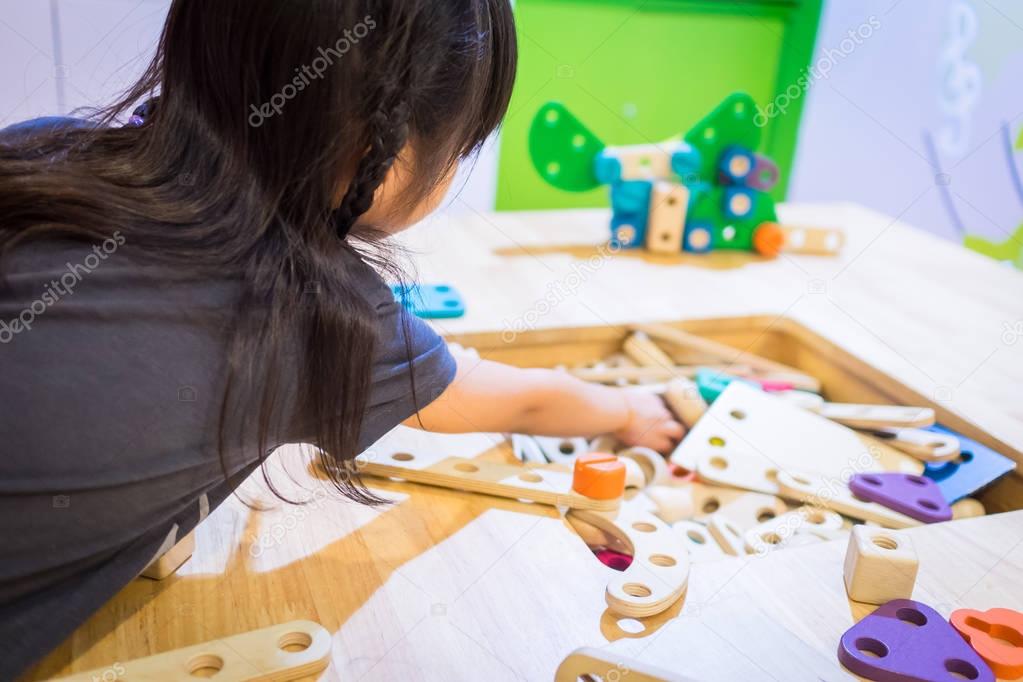 Kid hands building an education cart wooden toy block