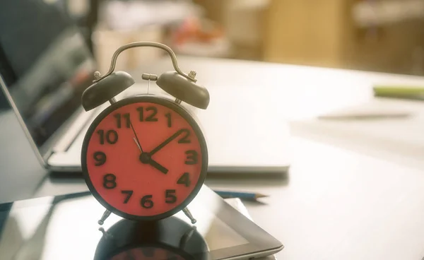 Es hora de ir a casa. El despertador contando al final del día en una mesa de oficina . — Foto de Stock