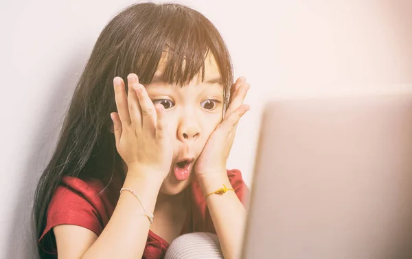 La pequeña asiática está conmocionada con lo que ve en Internet. El padre debe tener más cuidado en cómo su hijo usa las computadoras. . —  Fotos de Stock