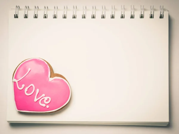 Love Heart Cookie Form auf einer leeren Buchseite. — Stockfoto