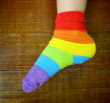 Gökkuşağı çok renkli çorap çocuk üzerinde ahşap zemin üzerinde besleme.