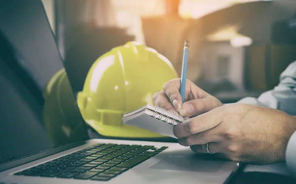 Trabajador de la industria de la construcción está tomando nota en la computadora . — Foto de Stock