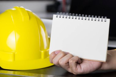 Mimar, inşaat işçileri, boş kitap sayfa tutan mühendisin el.